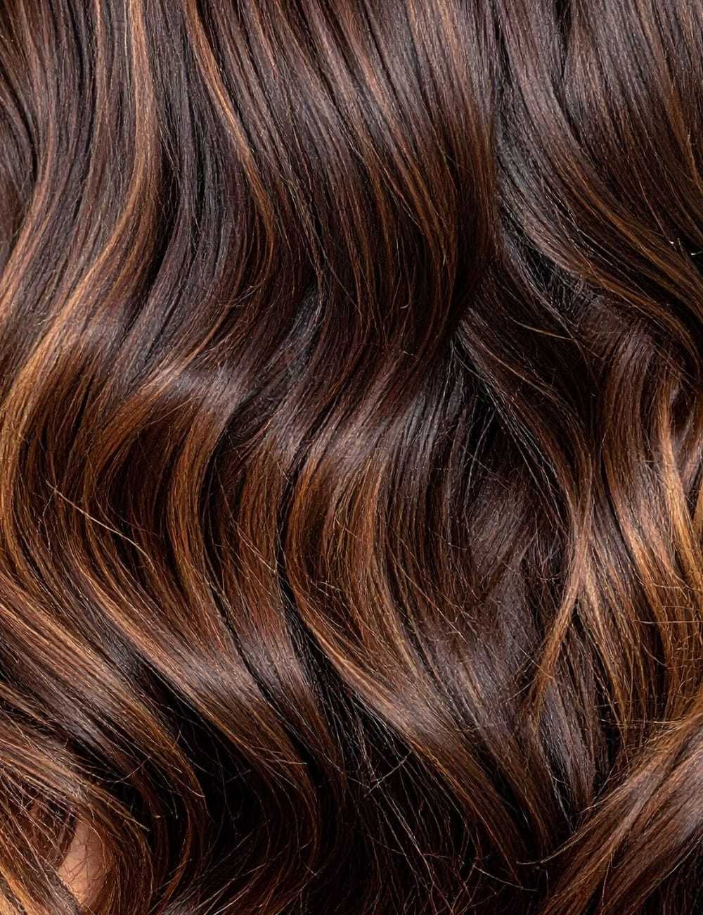 Rich, wavy brown hair with copper highlights.